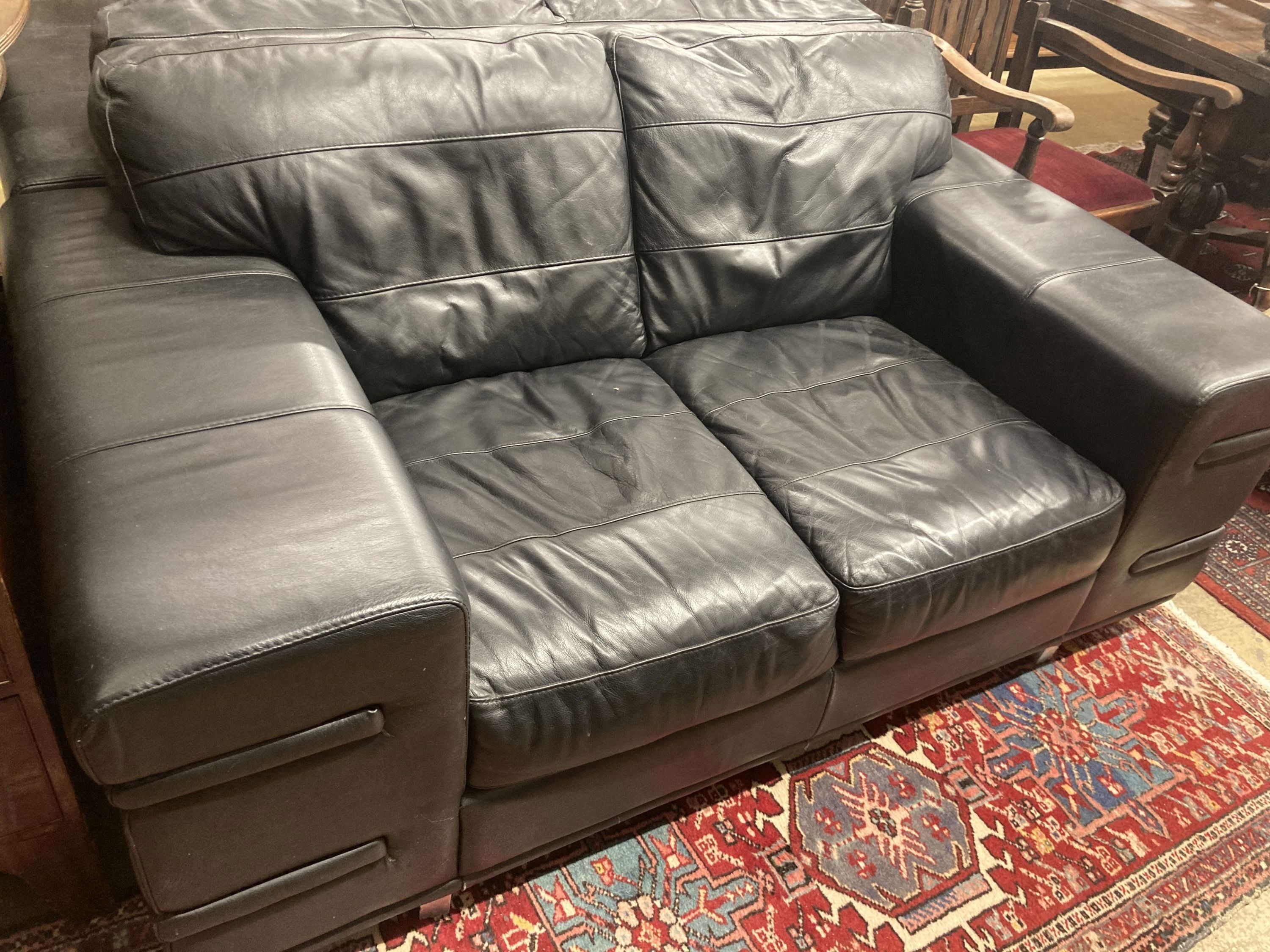 A pair of contemporary black leather two seater sofas, length 166cm, depth 92cm, height 70cm